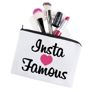 White canvas cosmetic bag with Insta Famous print and pink heart showing makeup brushes
