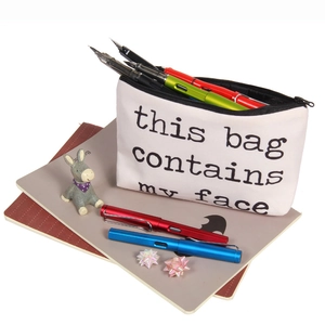 Detail view of canvas pouch with humorous lettering and black metal zipper for storage