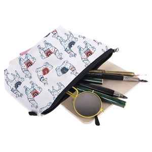 White travel cosmetic bag with alpaca print containing sunglasses and art brushes
