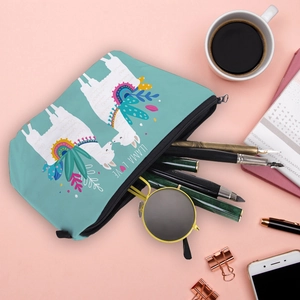 Lifestyle view of a teal llama love makeup bag with sunglasses and stationery items