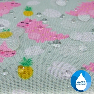 Macro de gouttes d'eau sur tissu imperméable avec imprimé de dinosaure mignon