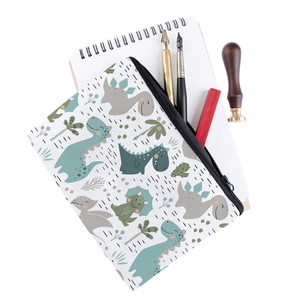 Detail view of canvas makeup bag with cartoon dinosaur prints and premium stationery props