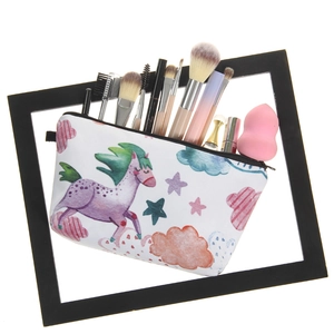 Unicorn print travel makeup bag with brushes inside, set against a white canvas background