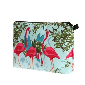 Close-up of tropical flamingo and green leaf print on a durable canvas cosmetic bag