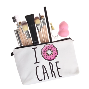 White canvas makeup bag with I Donut Care print and black zipper storage for cosmetics