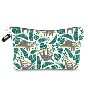 Detailed view of the sloth and monstera leaf print on a trapezoid toiletry bag