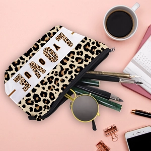 Flat lay of leopard print LOVE YOU makeup bag with office and travel accessories