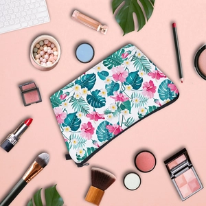 Floral print makeup bag with tropical hibiscus and monstera leaf pattern on pink background