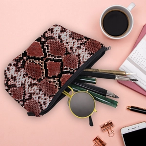 Multipurpose red snakeskin print makeup bag with zipper closure shown with daily essentials