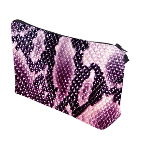 Detailed macro view of digital snakeskin pattern and zipper on trapezoid cosmetic bag