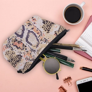 Chic snake print cosmetic bag with stationery and sunglasses on a stylish desk