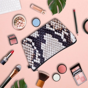 Macro view of snakeskin pattern leather makeup bag with zipper and cosmetic props