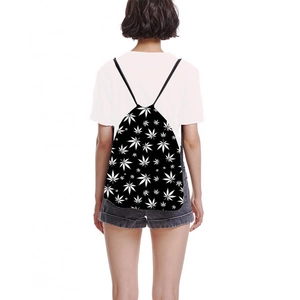 Unisex drawstring backpack with white leaf print on black fabric shown on model back