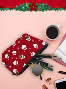 Flat lay of Christmas makeup bag with Santa print holding glasses and pens