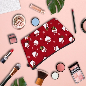 Flat lay of red Christmas makeup bag with Santa print among cosmetics and keyboard