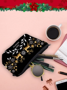 Flat lay of Christmas reindeer makeup bag with stationery and sunglasses on pink surface