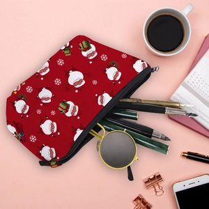 Christmas makeup bag with Santa print and zipper on a pink desk lifestyle setting