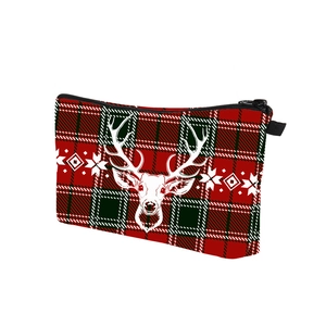 Detail of Christmas plaid cosmetic bag featuring a white reindeer head and snowflake print