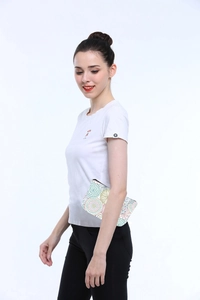 Detail of a floral mandala print toiletry bag held by a model in a white t-shirt