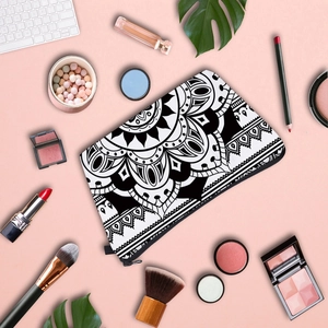 Close-up of mandala pattern makeup bag surrounded by cosmetics on a pink background