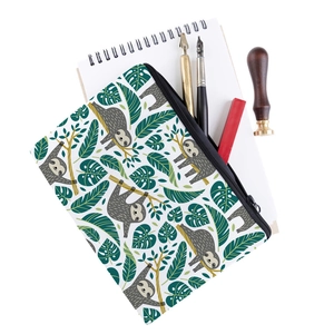 Flat lay of sloth print cosmetic bag with stationery accessories on a white desk