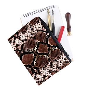 Détail d'une trousse à maquillage imprimé serpent avec fermeture éclair métallique noire