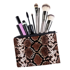 Détail de la trousse de maquillage à motif serpent avec pinceaux et rangement interne