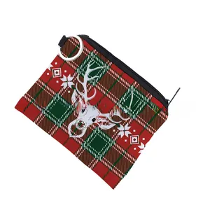 Macro detail of Christmas reindeer print coin purse with festive plaid pattern and zipper