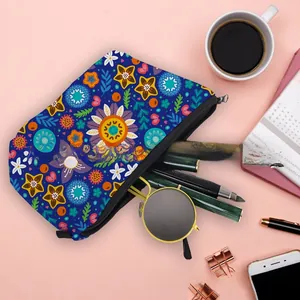 Flat lay of floral waterproof makeup bag storing sunglasses and pens on a pink desk
