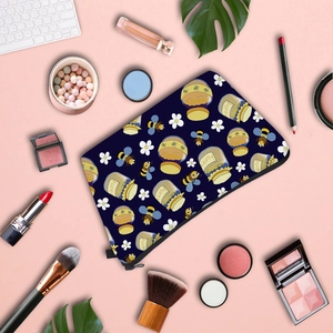 Navy blue water-resistant makeup bag with bee prints and honey pots on pink background