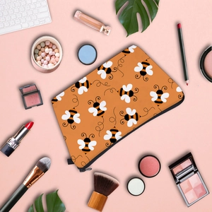Detailed flat lay of water-resistant honeybee print makeup bag with beauty accessories