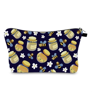 Detail of waterproof dark blue makeup bag with bee and honey jar prints and black zipper