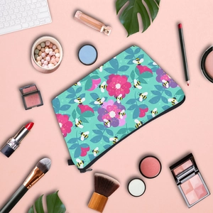 Waterproof bee print makeup bag with floral patterns on pink background with cosmetics