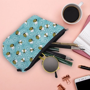 Flat lay of blue honey bee cosmetic bag with stationery accessories for daily storage