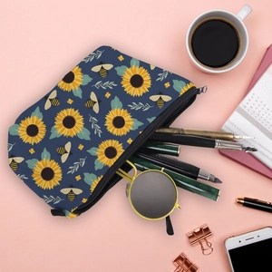Flat lay of water-resistant navy bee print makeup bag showing pens and sunglasses