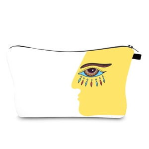 Detailed close-up of the evil eye art print and smooth zipper on a white canvas makeup bag
