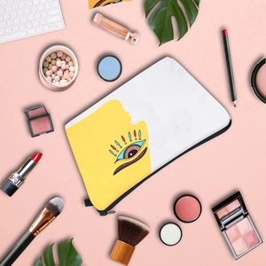 Flat makeup bag with Evil Eye print on yellow and white canvas with beauty tools