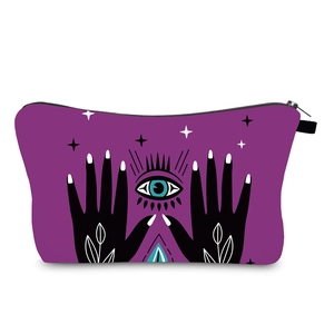 Detail view of water-resistant makeup bag featuring evil eye and mystic star prints