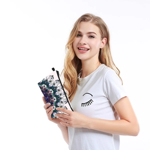 Waterproof mandala print travel makeup bag held by a model on a white background