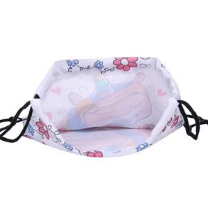 Détail du sac à cordon avec motifs licorne et fleurs sur tissu blanc léger
