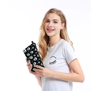 Fashionable skull print makeup bag held by a model, water-resistant toiletry clutch pouch