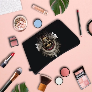 Flat lay of portable cosmetic bag with colorful tribal skull print among office accessories