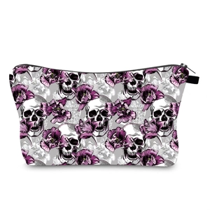 Detail of skull and purple floral print on rectangular portable makeup bag with black zipper