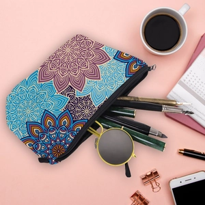 Detailed flat lay of mandala print makeup bag with black zipper on pink surface