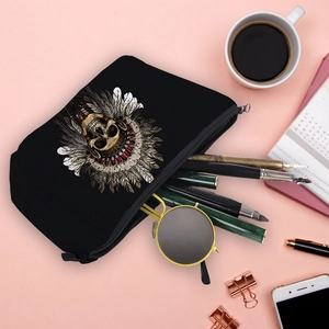 Portable skull print makeup bag with Indian feather headdress on a pink desk background