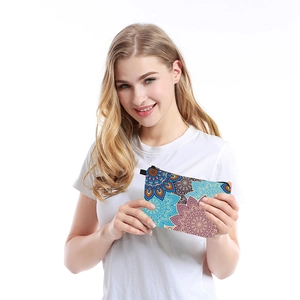 Close-up of mandala print waterproof cosmetic bag held by female hands for size reference