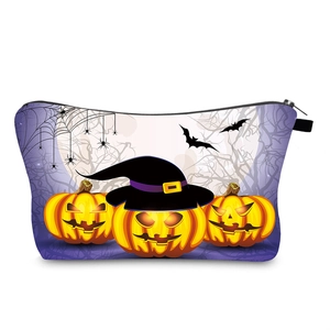 Detail of Halloween cosmetic bag with pumpkin and bat prints on purple fabric
