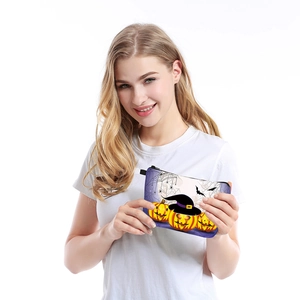 Waterproof Halloween makeup bag with pumpkin and bat prints held by model