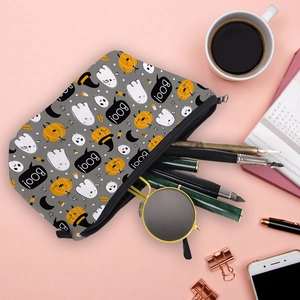 Trousse de maquillage Halloween avec fantômes et citrouilles sur bureau rose poudré