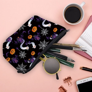 Halloween makeup bag with ghosts and pumpkins pattern on a desk with stationery